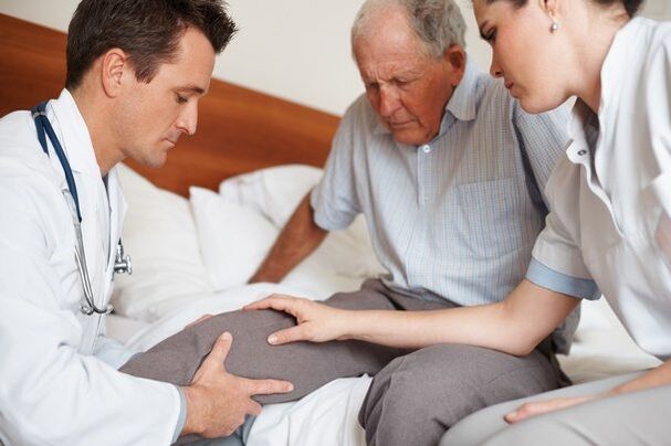 Il medico esamina il ginocchio del paziente